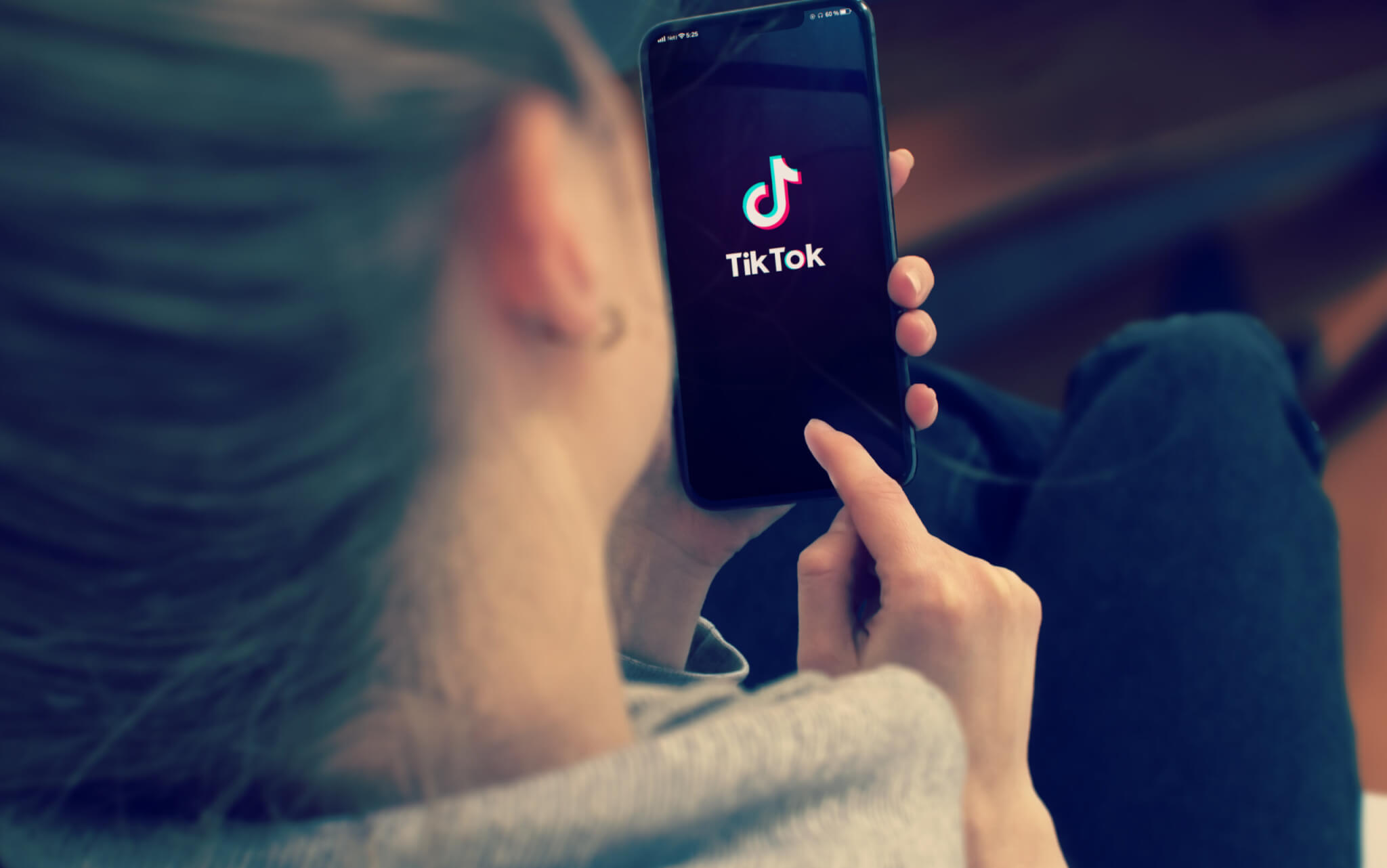 A smartphone displaying a short-form video app held in a hand.