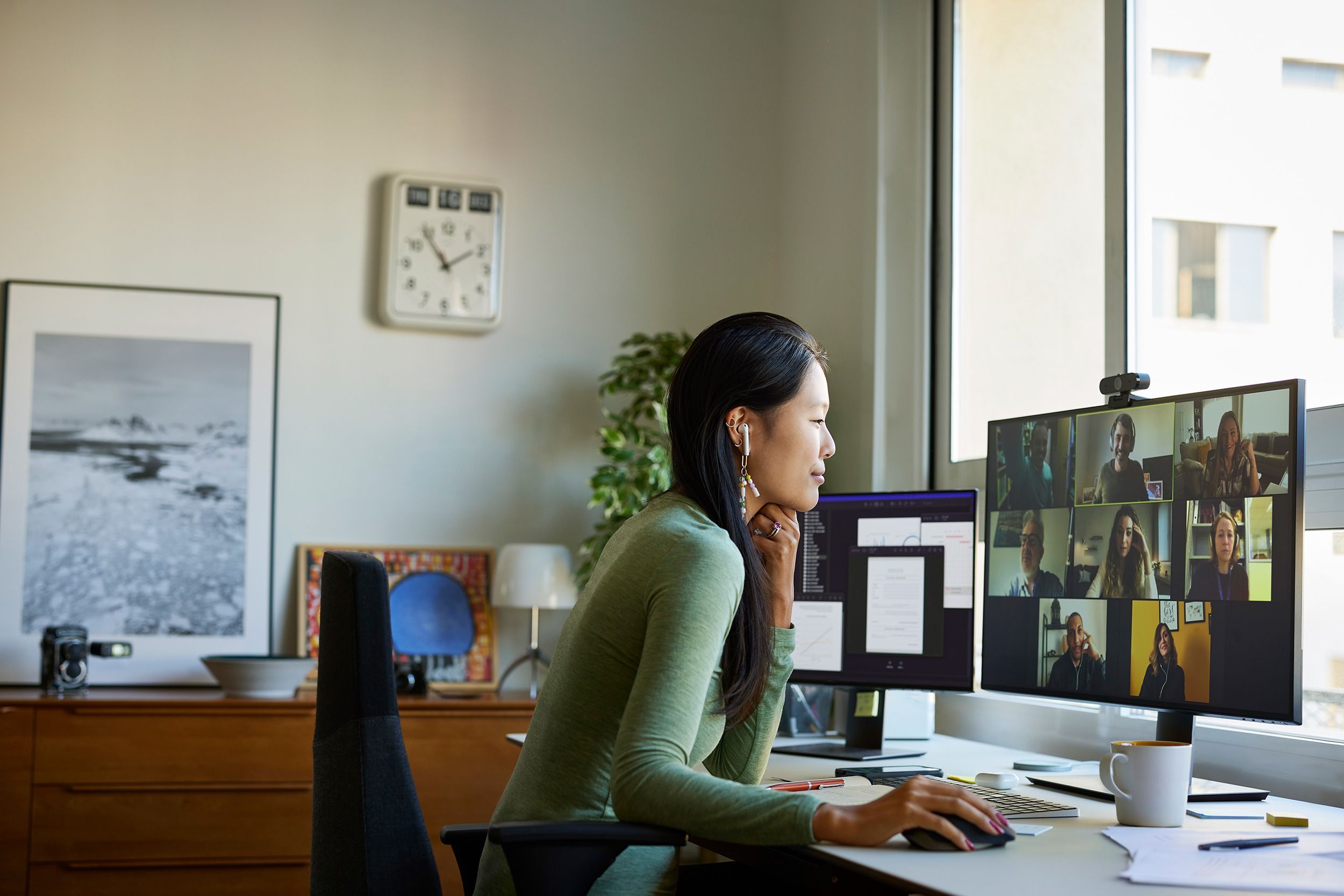 A remote worker joins a video meeting from a desk in her home office.